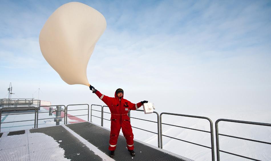 Die Ozonsondierungen werden bei jedem Wetter durchgeführt – auch wenn es an der Neumayer-Station stürmt. Auf diesem Foto lässt Thomas Schmidt, Meteorologe des Überwinterungsteams 2012 die Ozonsonde bei sehr windigen Bedingungen steigen.