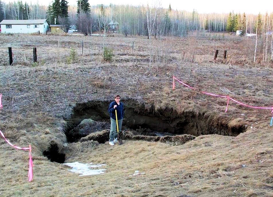 Der Permafrost-Forscher Vladimir Romanovsky von der Universität Alaska Fairbanks posiert vor einem Bereich, wo der Boden durch den Verlust des Permafrostes eingebrochen ist. Gemäss dem Forscher müssen sich die Bewohner arktischer Regionen häufiger auf solche Ereignisse vorbereiten. Bild: UAF